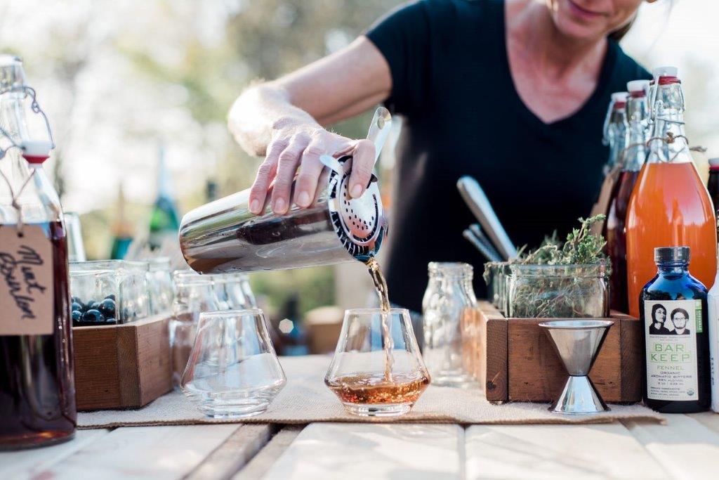 Server pouring a drink at an intimate gathering event catered by Liquid Assets.