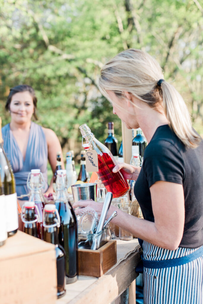 A woman pouring wine at a wedding reception.